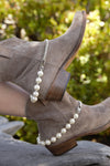 Buff colored cowboy boots with white pearl spurs with steel chains